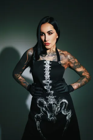 Agnė Pranckevičiūtė su juoda darbo prijuoste, ant kurios atspausta anatominė stuburo grafika