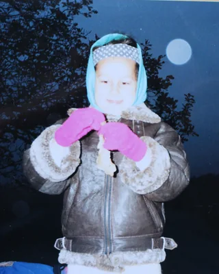 Vaikystė: žiemą lauke, su skarele ir rožinėmis kumštinėmis, danguje šviečia mėnulis